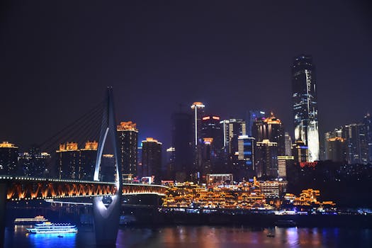 重庆夜色中，充满活力的现代天际线和灯光桥梁倒映在长江之上