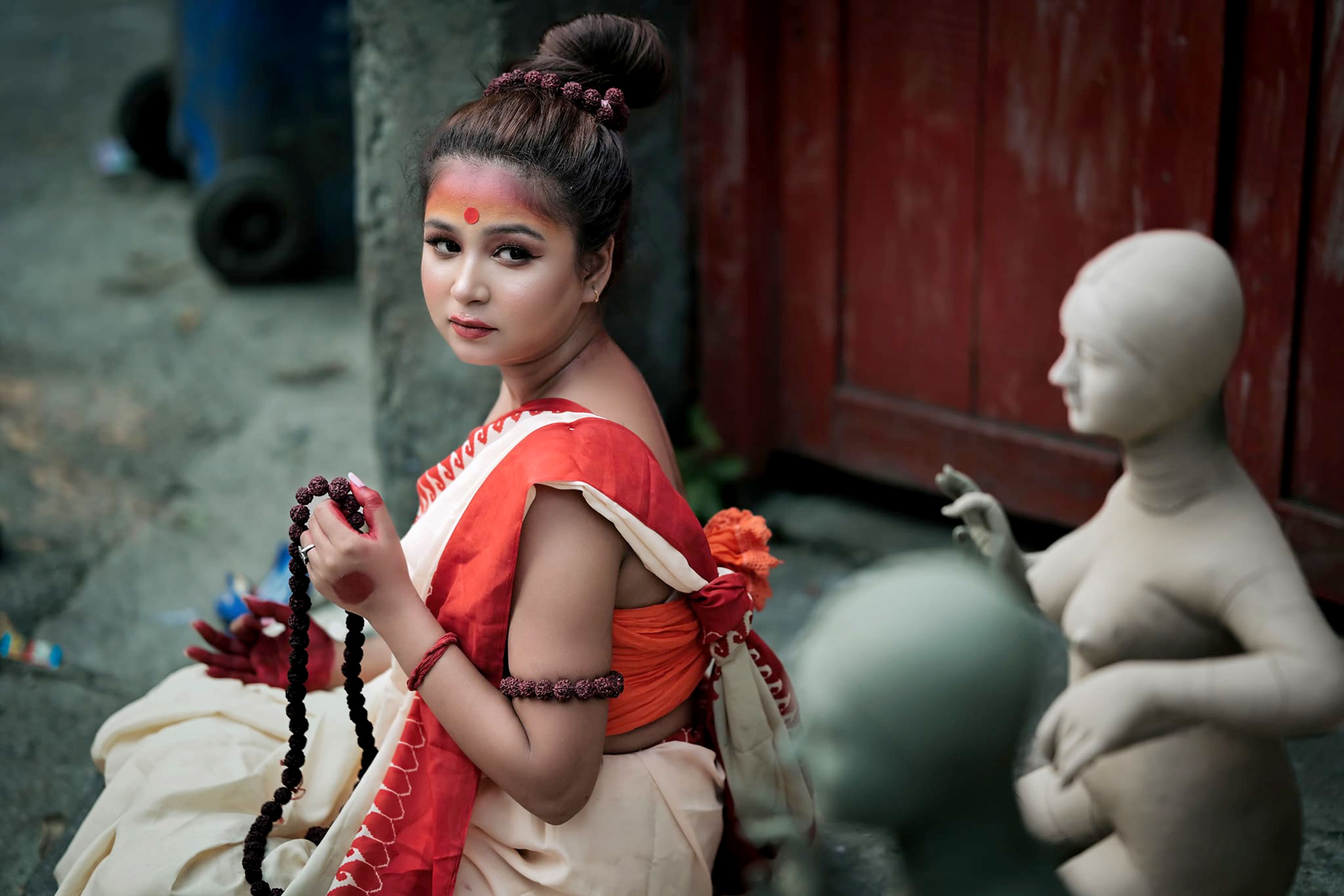 Traditional Woman with Prayer Beads and Sculptures · Free Stock Photo