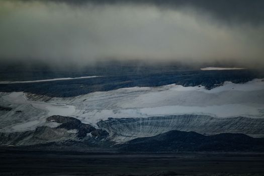 A dramatic scene of an Arctic glacier under a foggy, overcast sky, conveying a cold, moody atmosphere.