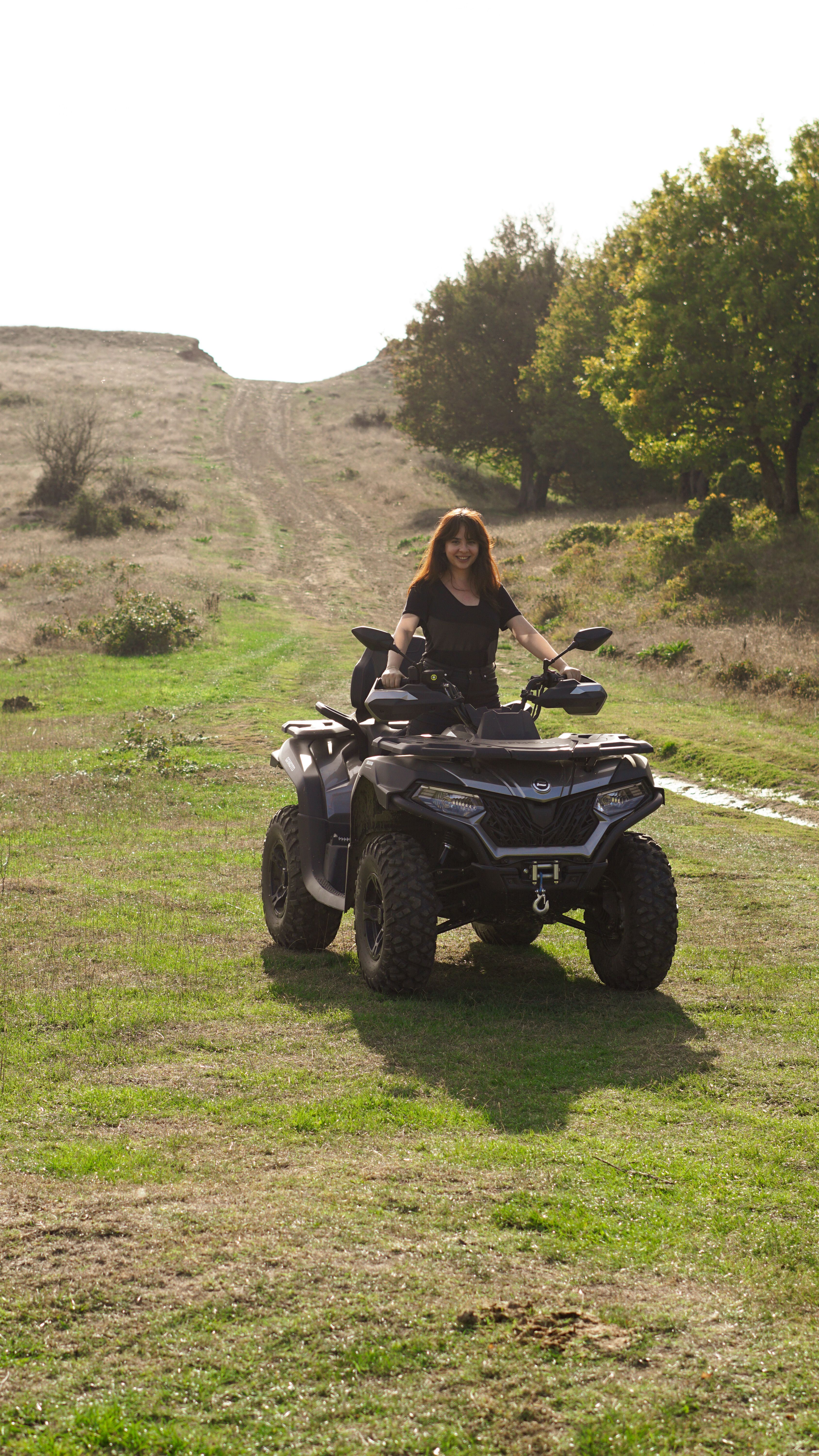 Woman Riding ATV in Open Field on Sunny Day · Free Stock Photo