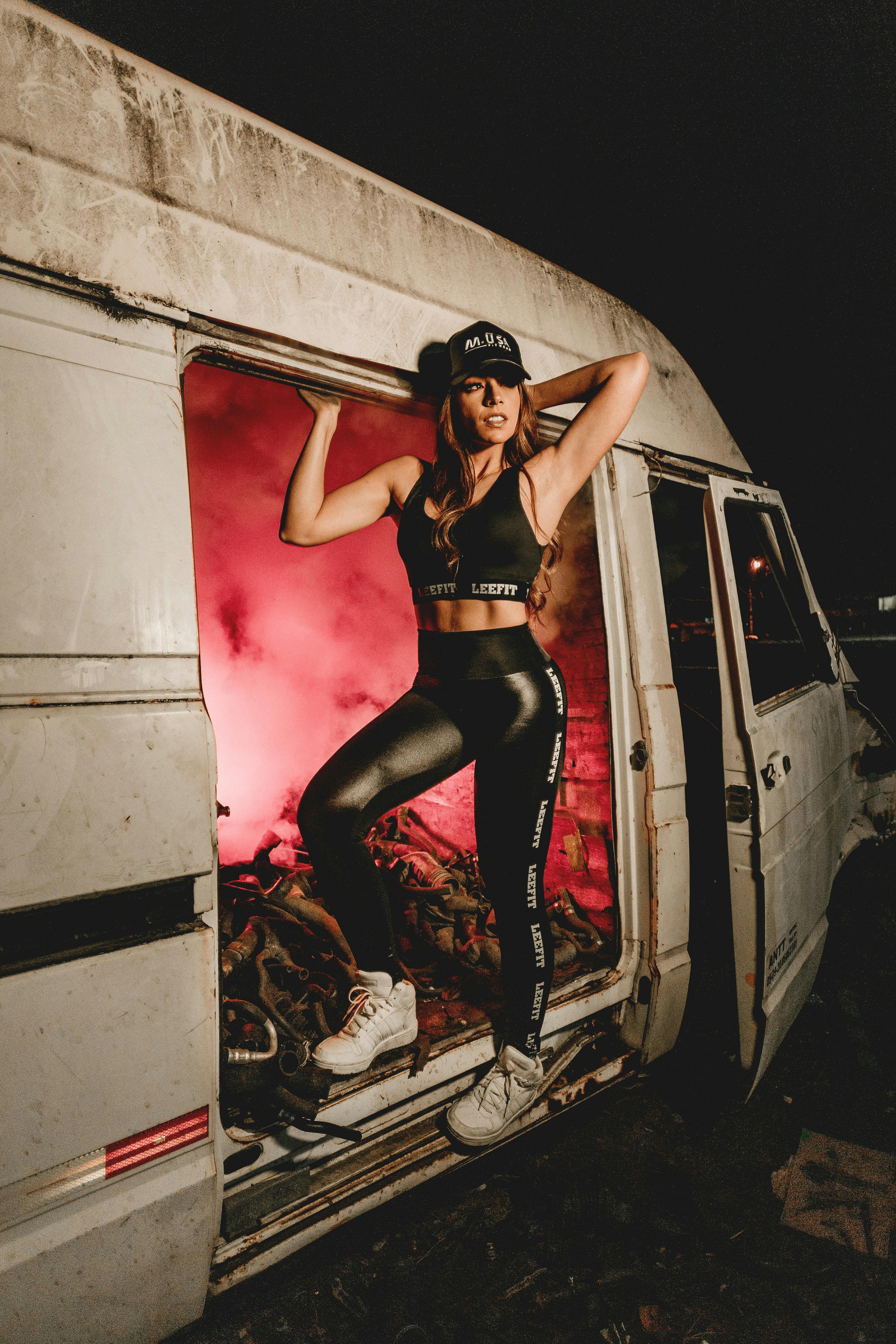 时尚模特在前卫的城市环境中摆姿势，灯光效果呈现红色