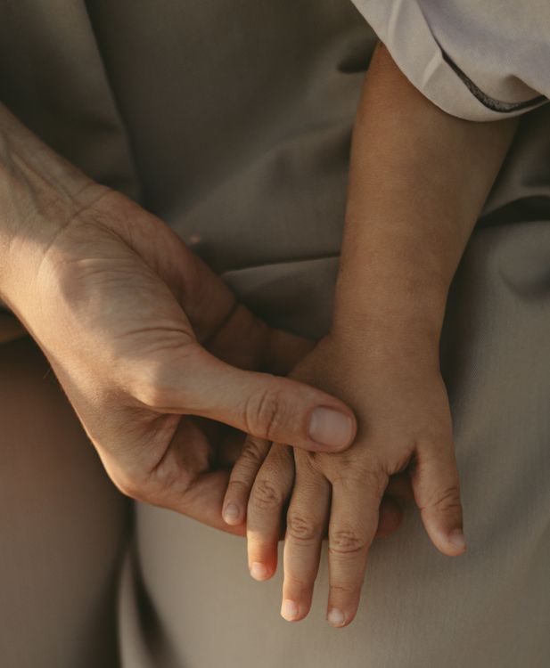 Χέρι ενήλικα κρατά προστατευτικά το χέρι παιδιού
