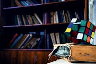 一本破旧的书上，放着一个生动的魔方，在舒适的图书馆环境中