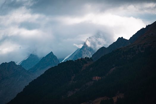Dark, dramatic mountains with cloud cover creating a moody, atmospheric scene.