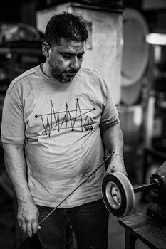 Black and white photo of an artisan at work in an Istanbul workshop, focused and skilled.
