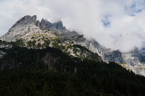 Free Stunning view of rugged mountain peaks partially hidden by clouds revealing dramatic scenery. Stock Photo