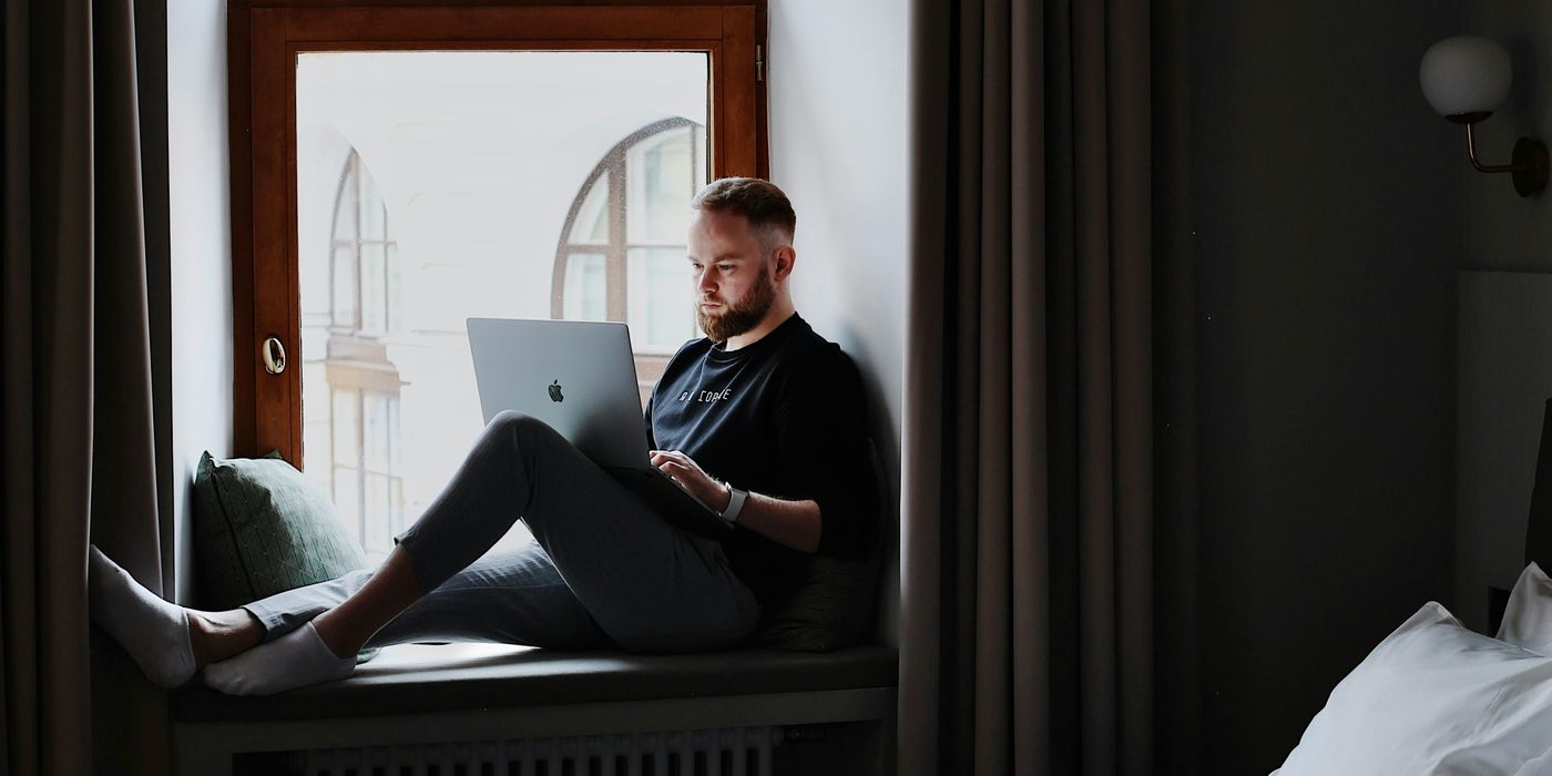 Traveler with a laptop in a hotel room booking a stay