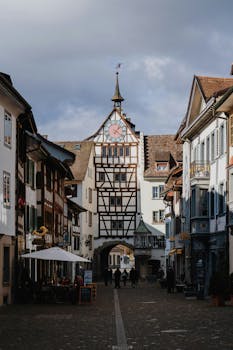 Picturesque medieval street scene featuring a historic clock tower in a quaint town.