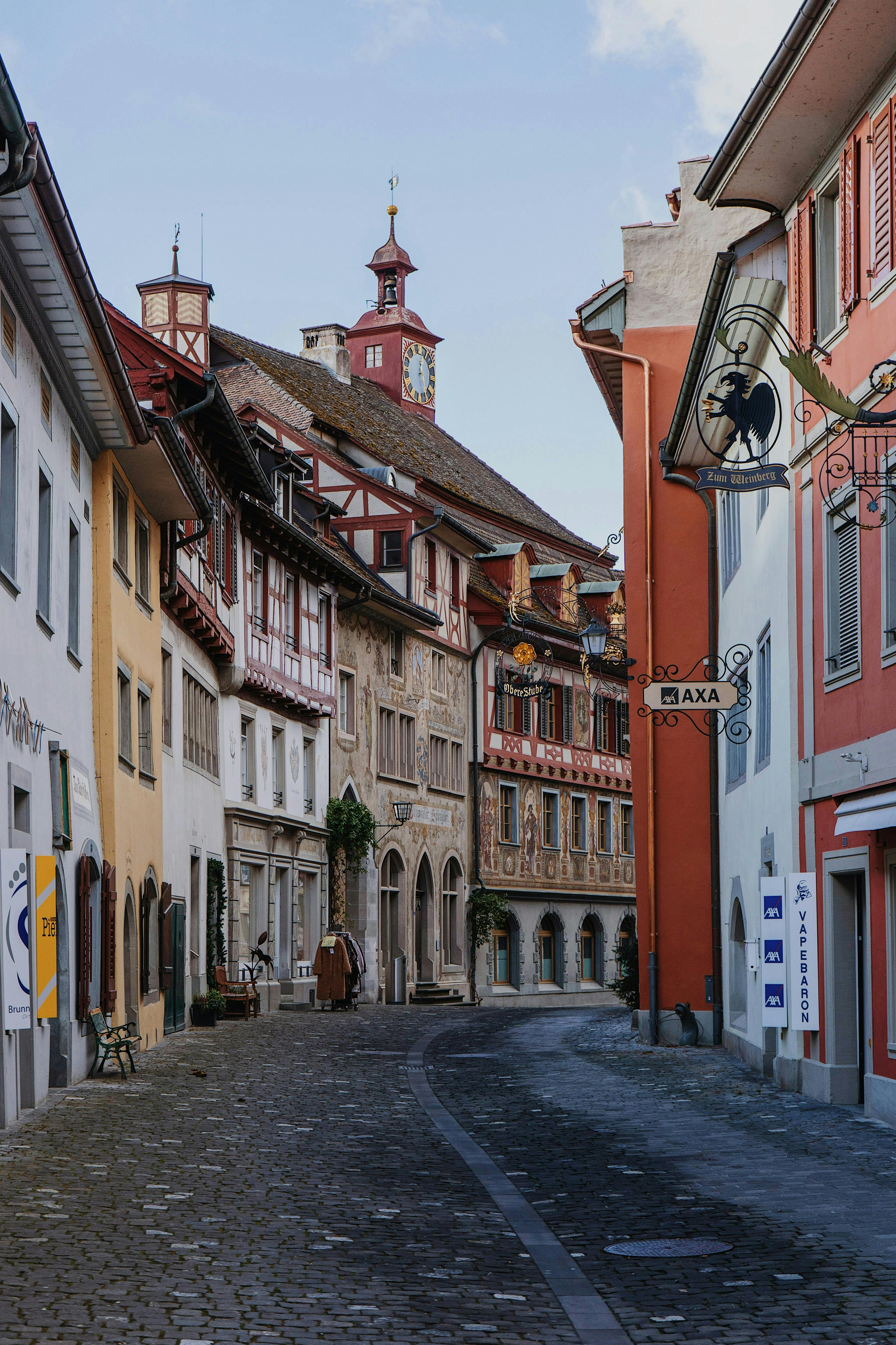 Scenic view of a quiet, cobblestone street lined with colorful historical buildings in Europe.
