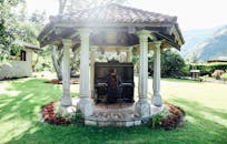 花园凉亭里，绿树成荫，一个人正在弹钢琴