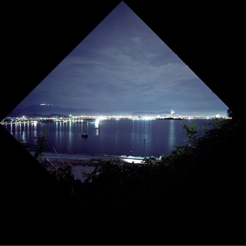 Free A mesmerizing night view of a city bay with glowing lights reflected on the water. Stock Photo