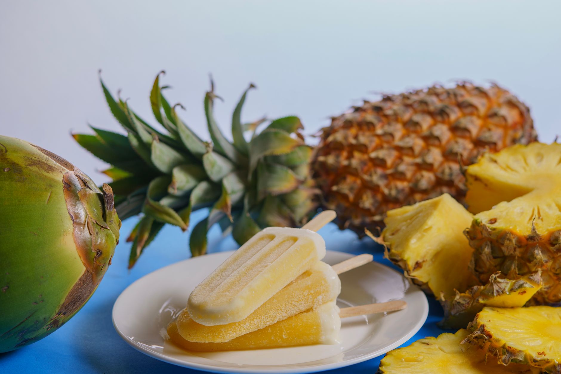 Fresh pineapple juice with lemon and ginger on a rustic table