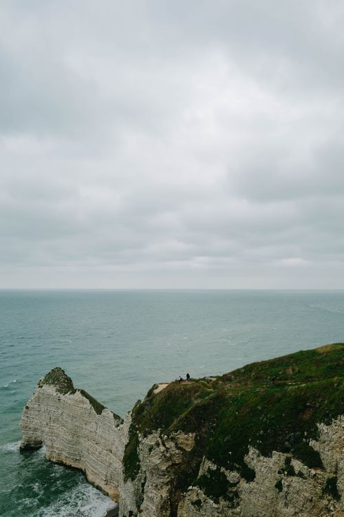 Free Breathtaking ocean view from a high cliff with overcast sky and greenery. Stock Photo