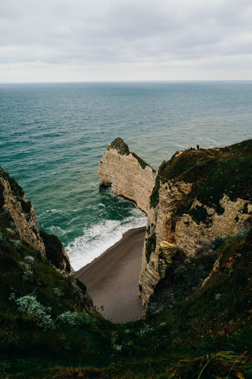 Free Majestic coastal cliffs with a secluded beach below, captured on an overcast day. Stock Photo