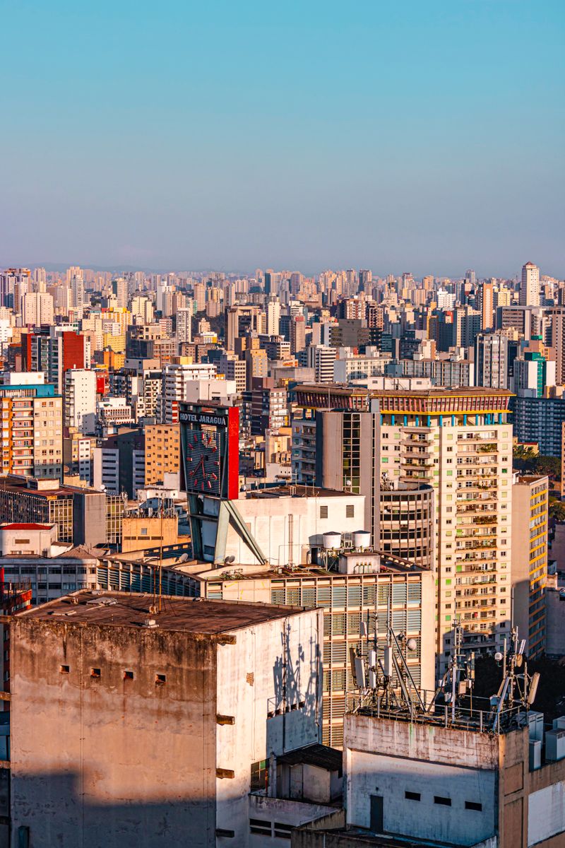 Aerial view of São Paulo's dense urban skyline under a clear blue sky.
