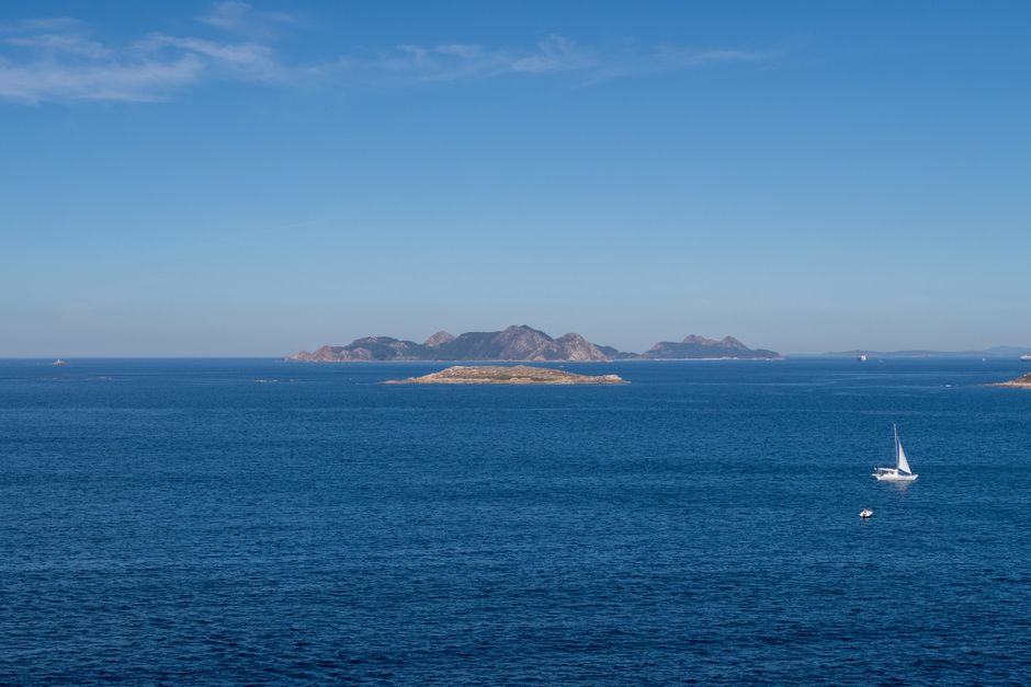 Stunning Shared Yacht Tour with Drinks Lunch and Snorkeling Review: The Ultimate Spain Yacht Experience Review 2026 - A serene view of the ocean with a sailboat and distant islands under a clear blue sky.