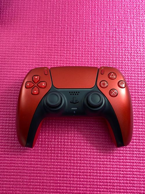 Free Red gaming controller on pink mat, contrasting vivid colors for dynamic gaming setup. Stock Photo