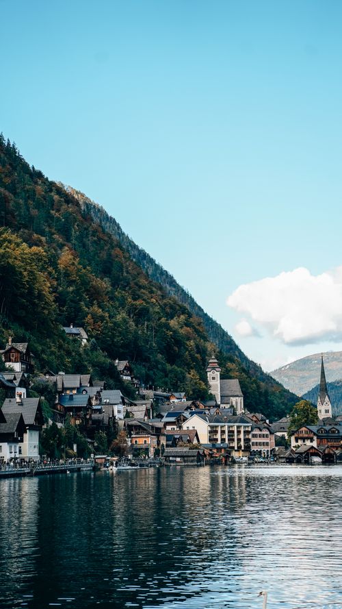 Free Picturesque view of Hallstatt village located by a serene lake with mountains in the background. Stock Photo