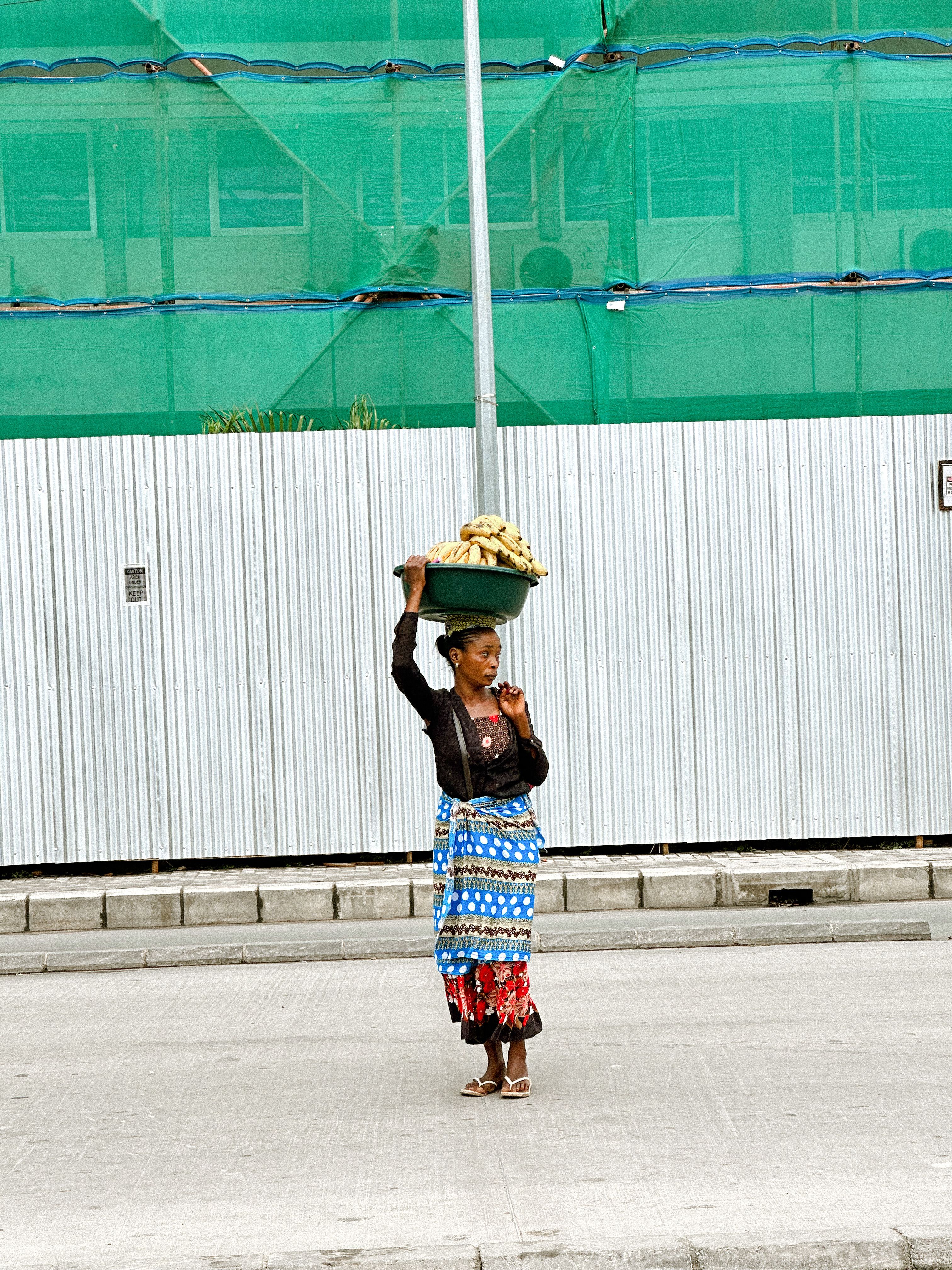 Woman Balancing Basket on Head in Urban Setting · Free Stock Photo