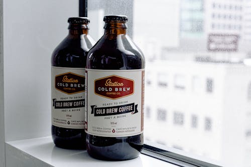 Free Close-up Photo of Station Cold Brew Coffee Bottles by Window Stock Photo