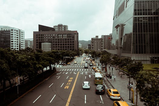 A bustling urban cityscape with traffic, skyscrapers, and pedestrians on a lively day.