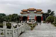 郁郁葱葱的绿色植物环绕着迷人的中国传统大门，周围还有游客