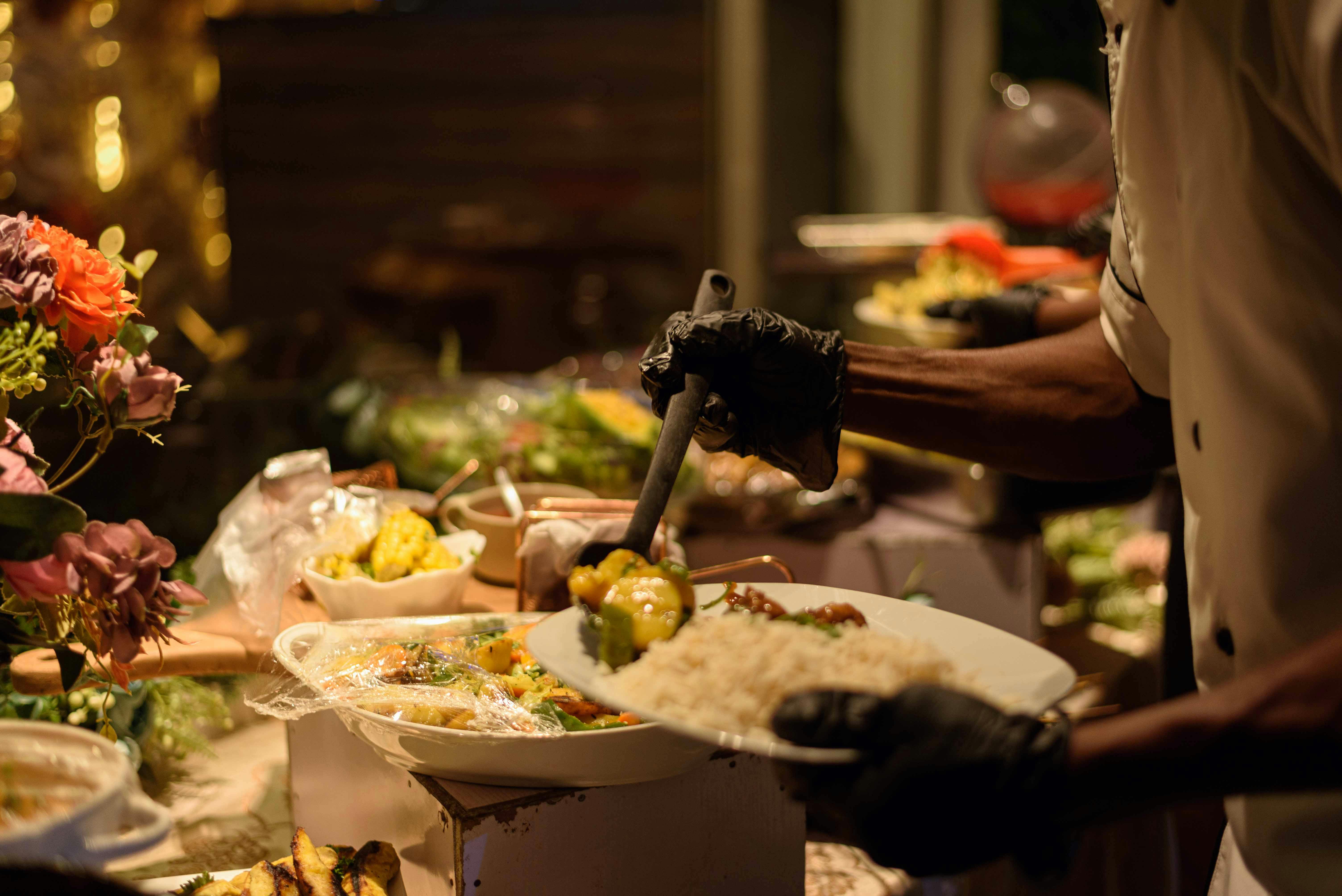 A chef serving traditional Nigerian dishes at an elegant buffet in Enugu, Nigeria.
