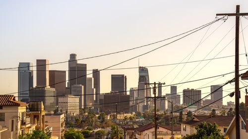 Free Capture of downtown Los Angeles skyline under a warm sunset, showcasing iconic skyscrapers and urban landscape. Stock Photo