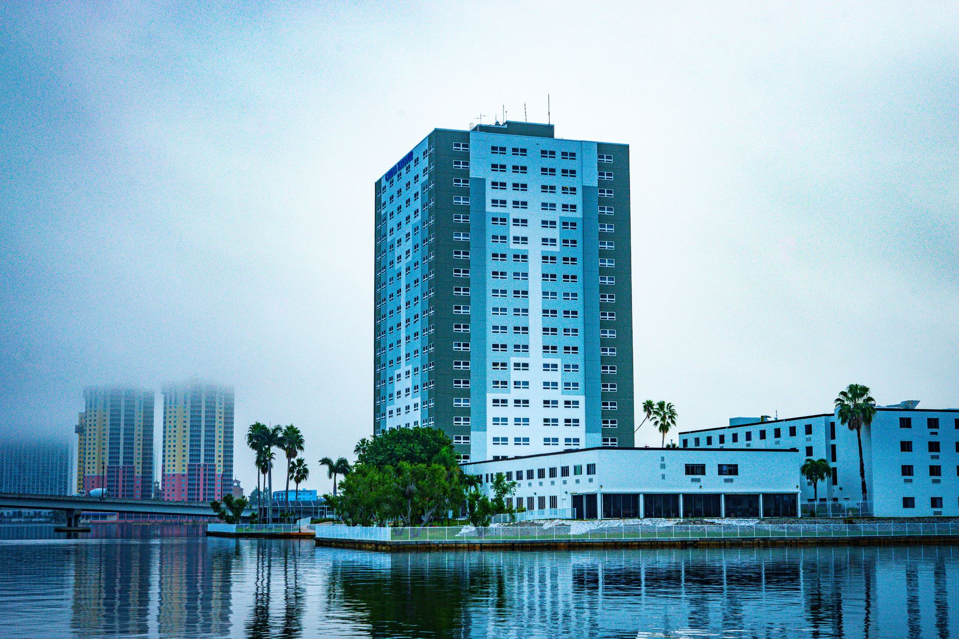 Tall building next to a river under an overcast sky in Fort Myers, Florida.