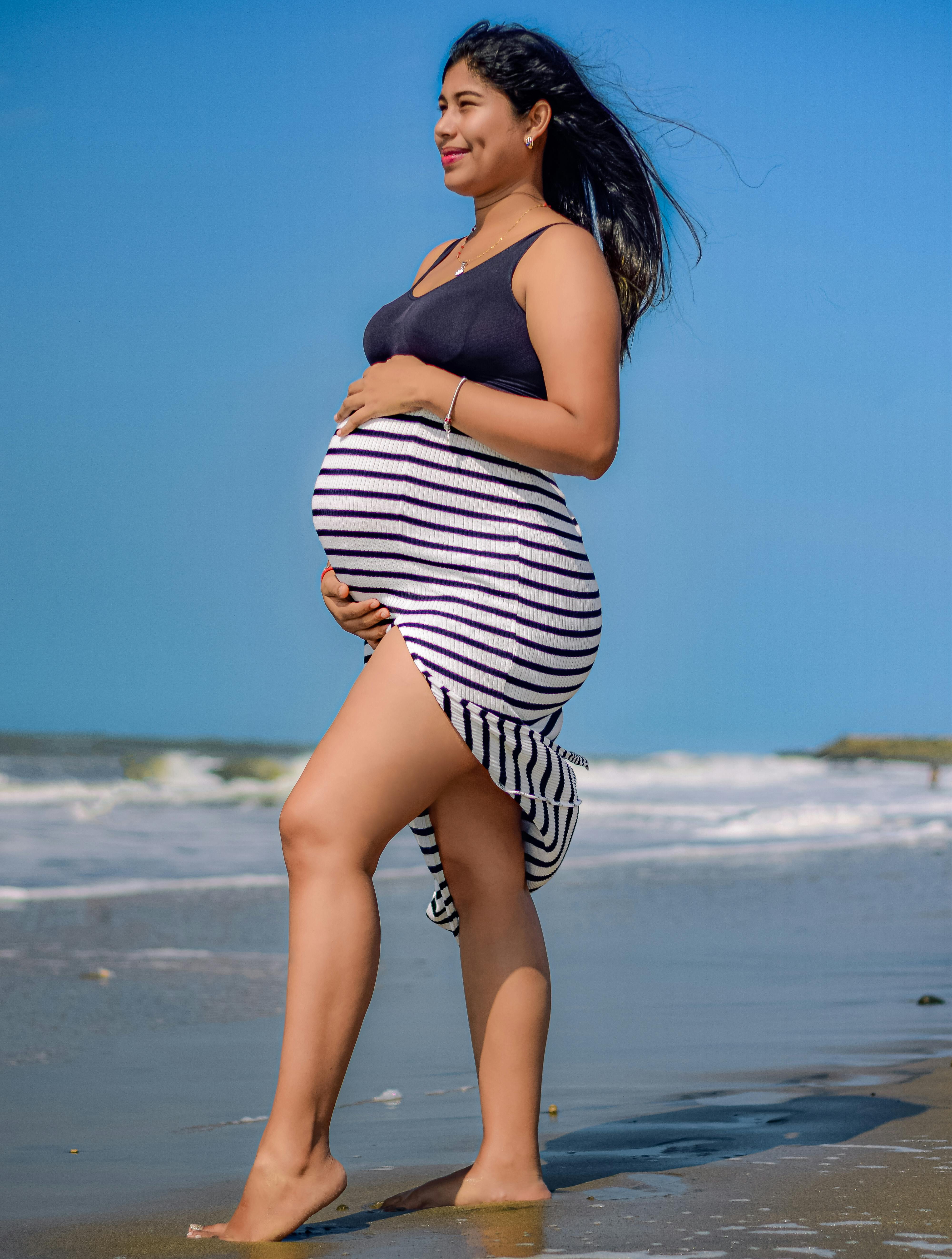 pregnant woman enjoying beach walk in summer