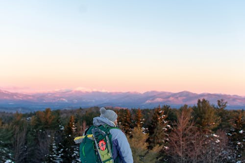 Man Wearing Green Backpack Overlooking The Woods