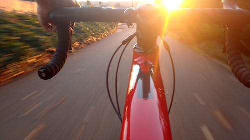 Free Person, Die Auf Dem Roten Rennrad Während Des Sonnenuntergangs Reitet Stock Photo