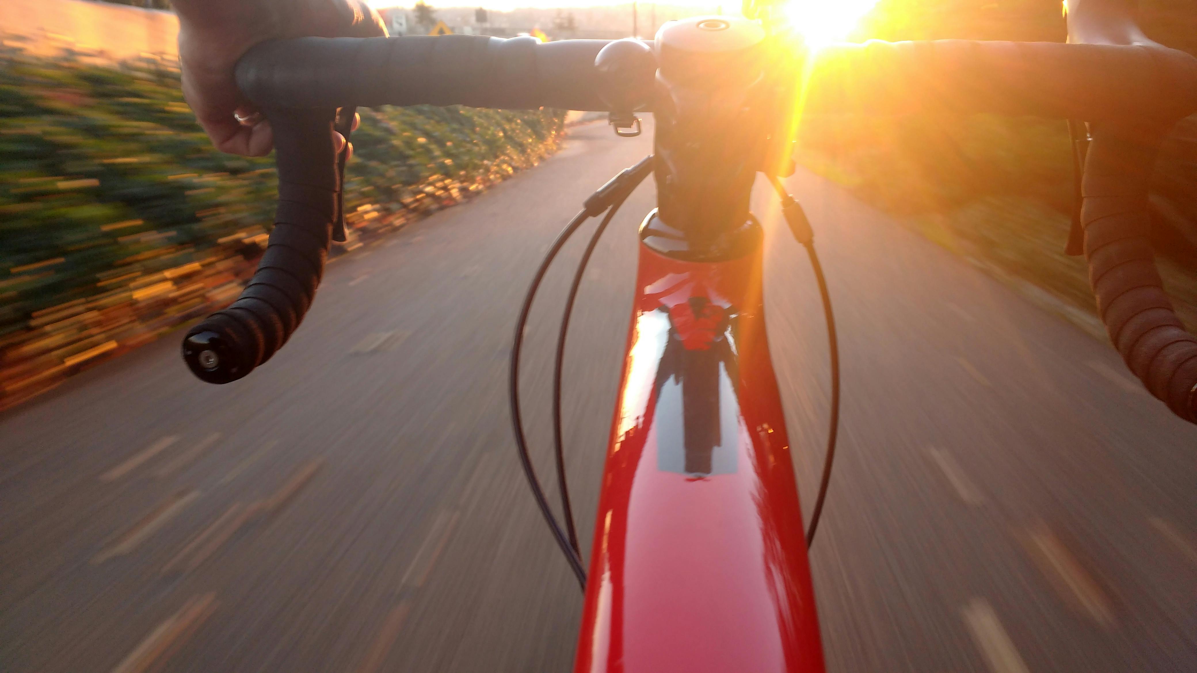 Person Riding on Red Road Bike during Sunset · Free Stock Photo