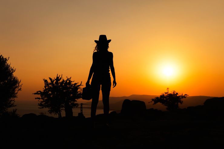 A figure in a wide-brimmed hat silhouetted against a sunset — photo by Vural Yavas on Pexels