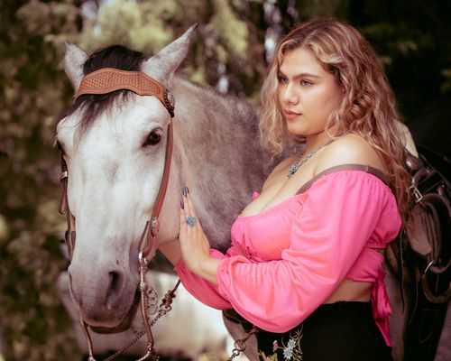 Free A young woman with curly hair in pink embraces a white horse outdoors, exuding peace and connection. Stock Photo
