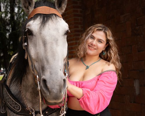 Free Woman in pink blouse smiles beside a white horse outdoors, showcasing a bond. Stock Photo