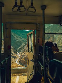 Captivating view of mountains from a bus window, showcasing a winding river.