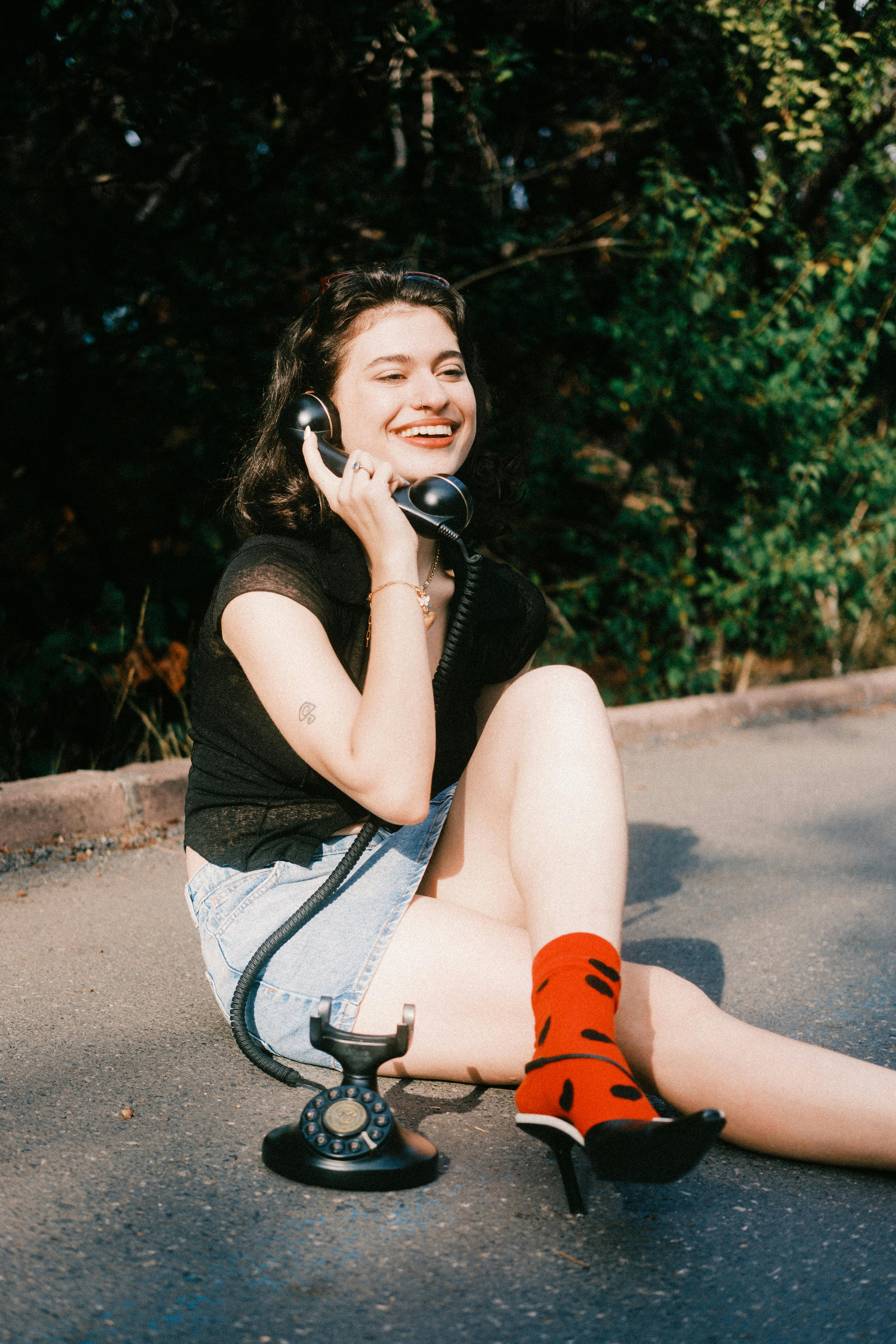 grátis Jovem Mulher Aproveitando Um Telefone Vintage Ao Ar Livre Foto profissional