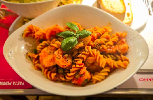 A mouthwatering dish of fusilli pasta with seafood and fresh basil garnish, perfect for foodies.