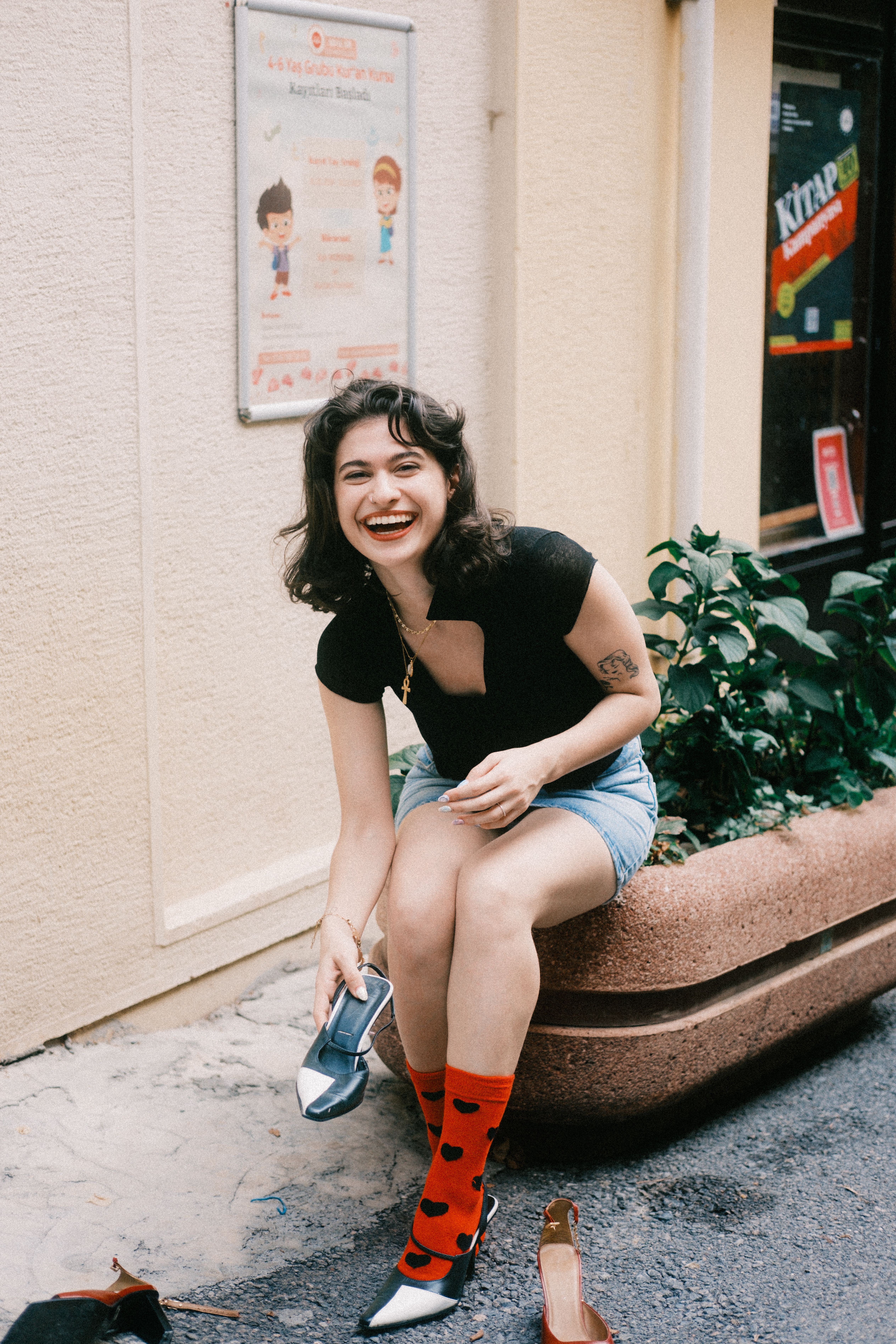Happy woman in urban setting trying on shoes with vibrant socks.