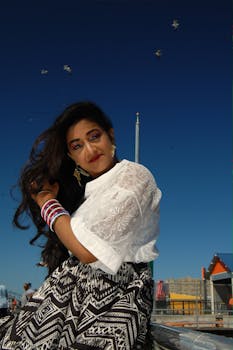 一位穿着时尚服装的迷人女子在户外靠着栏杆微笑