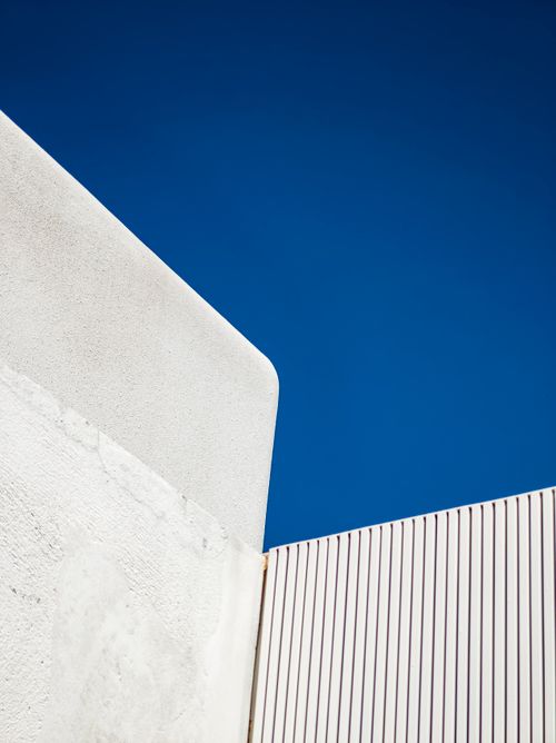 Free Modern architecture with geometric lines contrasts sharply against a vivid blue sky. Stock Photo