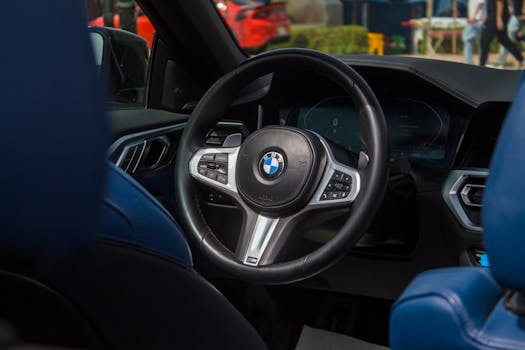 Close-up view of a luxury car's steering wheel with modern design and blue interior.