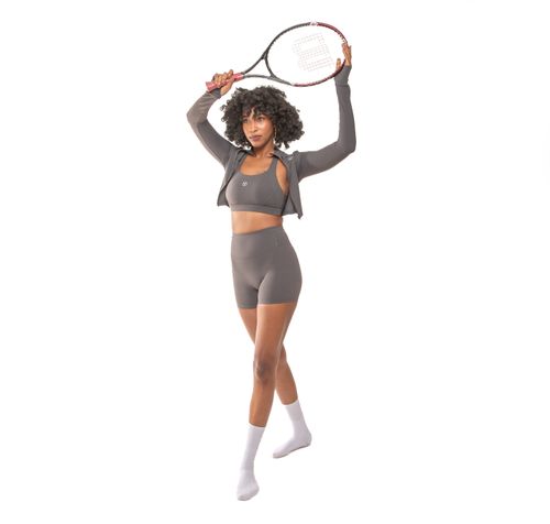 Free Athletic woman posing with tennis racket, showcasing stylish sportwear on a white background. Stock Photo
