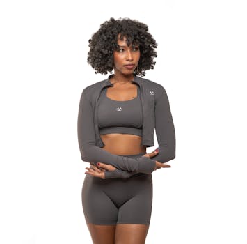 A confident woman poses in stylish gray athletic wear, embodying fitness and fashion.