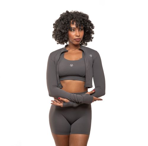 Free A confident woman poses in stylish gray athletic wear, embodying fitness and fashion. Stock Photo