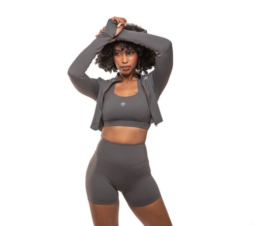 Free Confident woman in gray sportswear posing on white background. Stock Photo