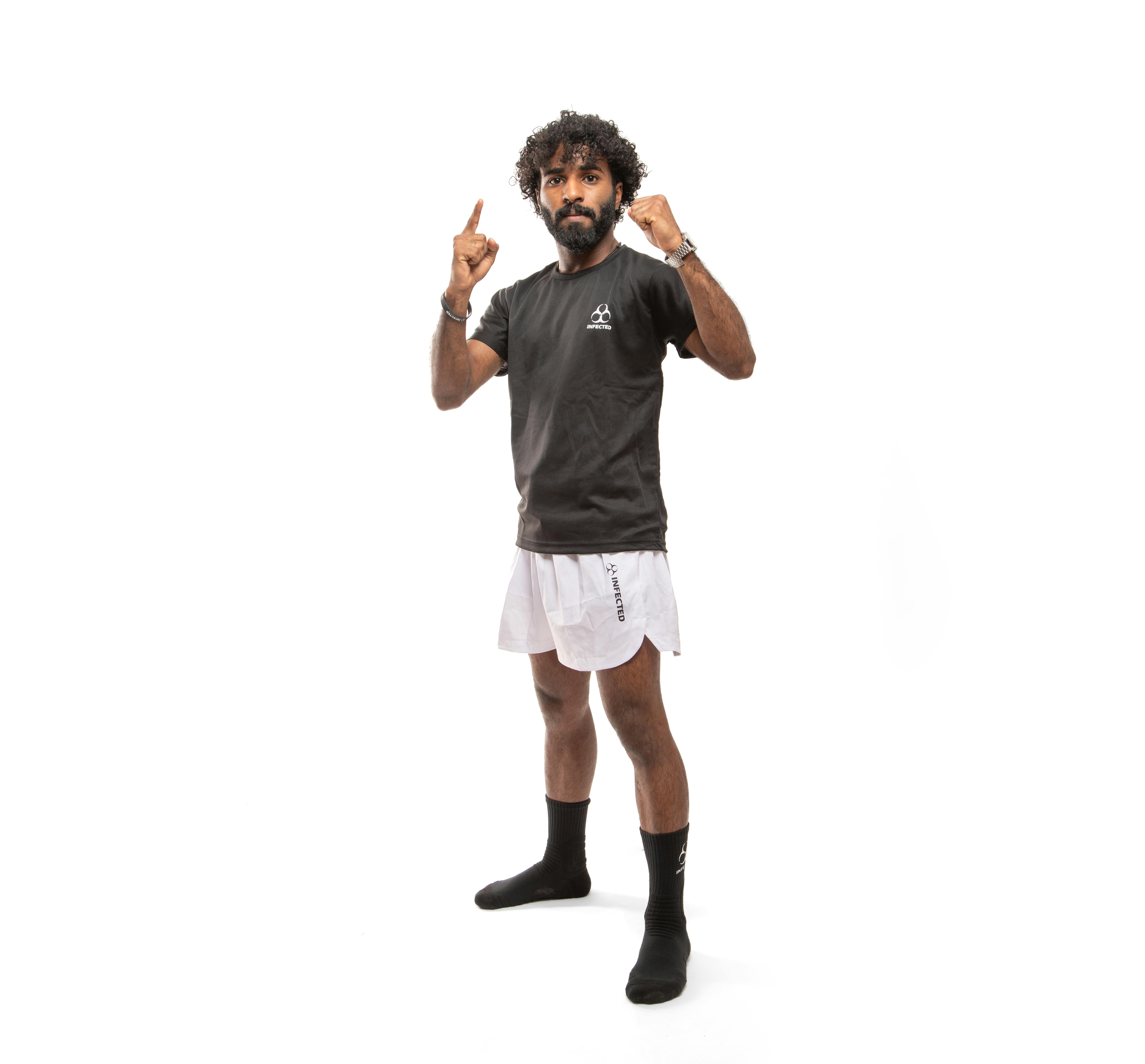 무료 흰색 스포티한 의상을 입고 포즈를 취하는 자신감 넘치는 남자 스톡 사진