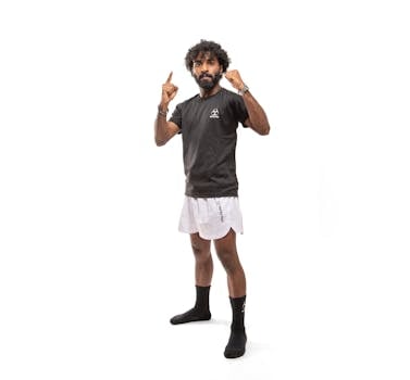 Strong and confident man in sportswear striking a powerful pose against a white background.