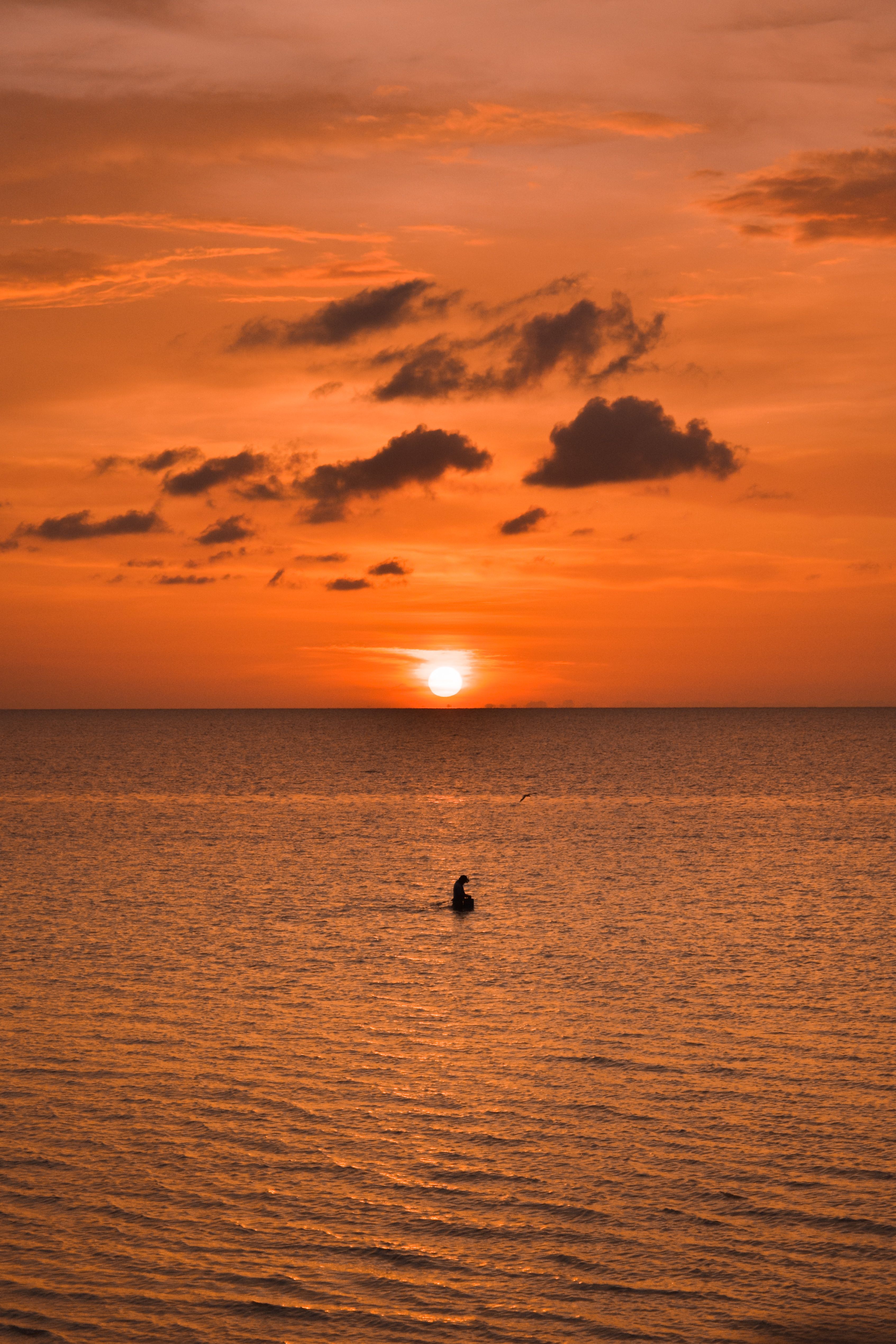 Serene Sunset Over Ocean with Silhouette · Free Stock Photo